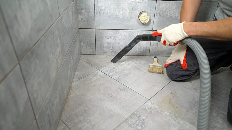 Ein Arbeiter reinigt Keramikfliesen auf dem Boden